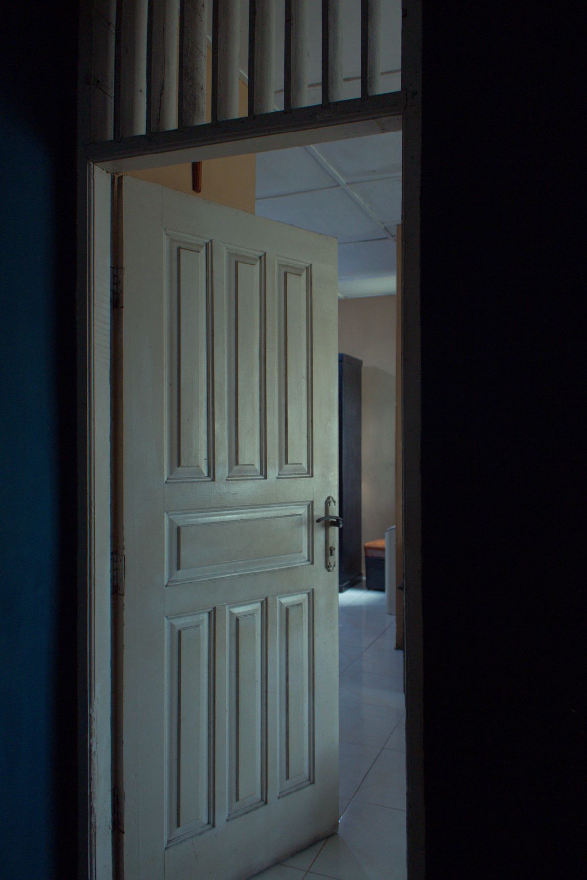 Puerta blanca abierta en un pasillo con luz natural