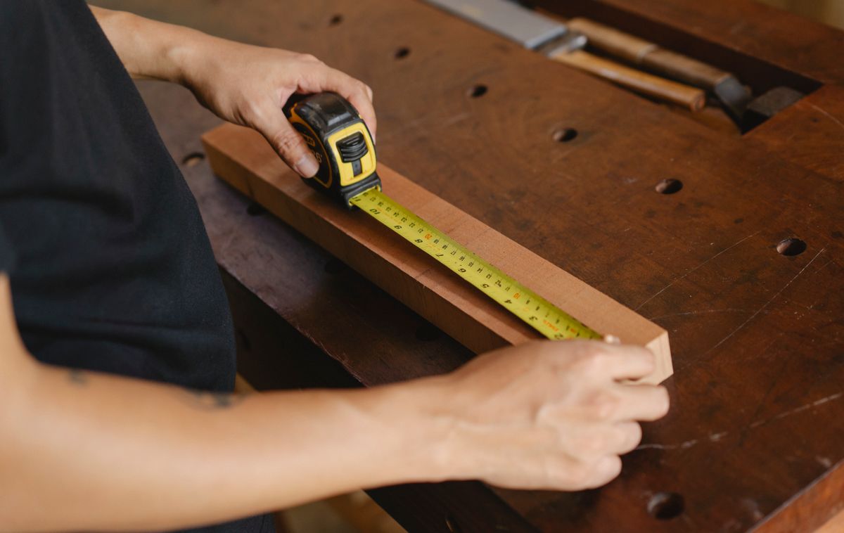 Cinta métrica sobre madera en un taller de carpintería