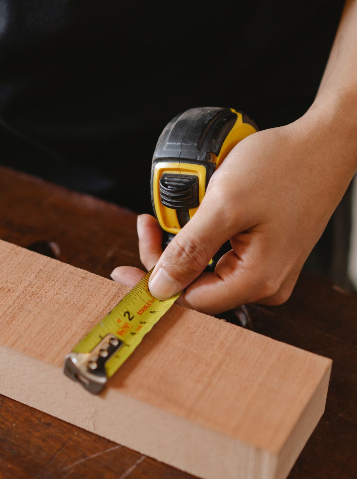 Medición de madera con cinta métrica en un taller