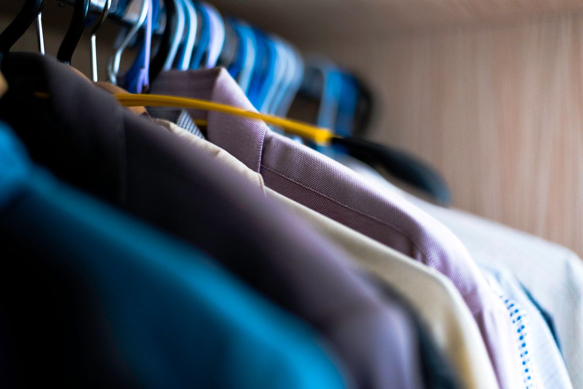 Barra de colgar con ropa organizada en un armario